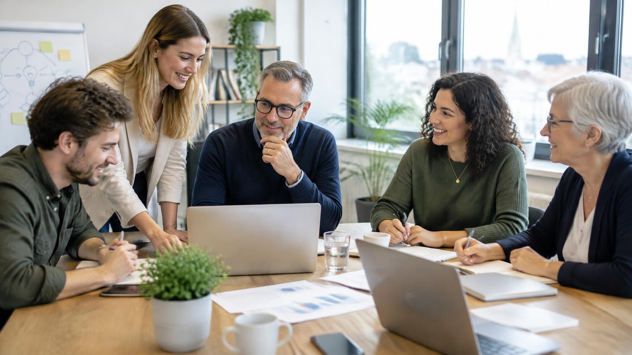 Colleagues collaborating around a table in a bright office